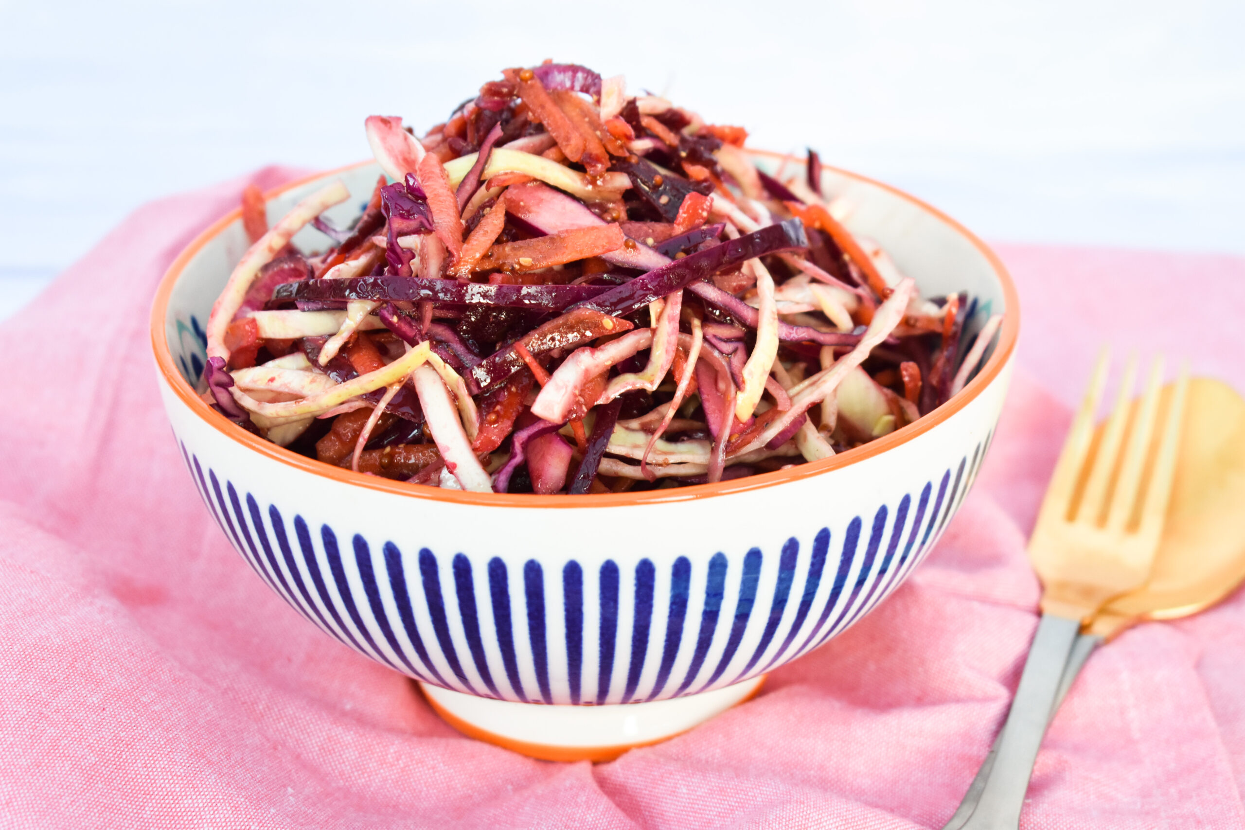 Colourful balsamic beet slaw with a tangy dressing in a bowl.