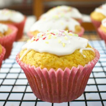 Vegan lemon muffins topped with lemon icing and sprinkles
