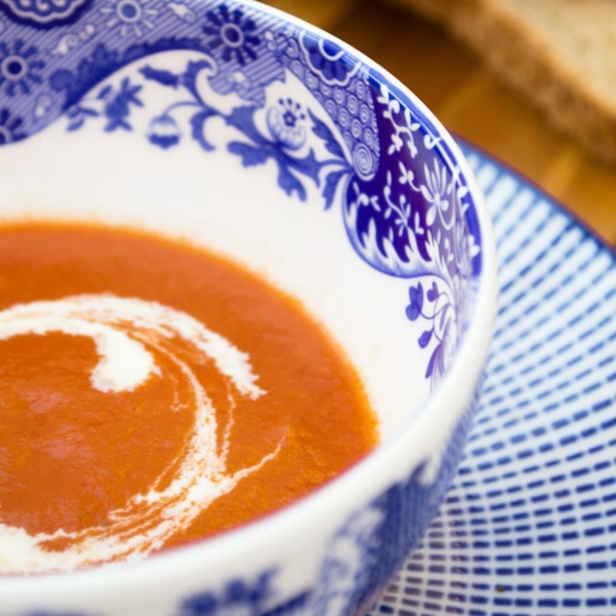 A bowl of vegan tomato soup with a swirl of cream