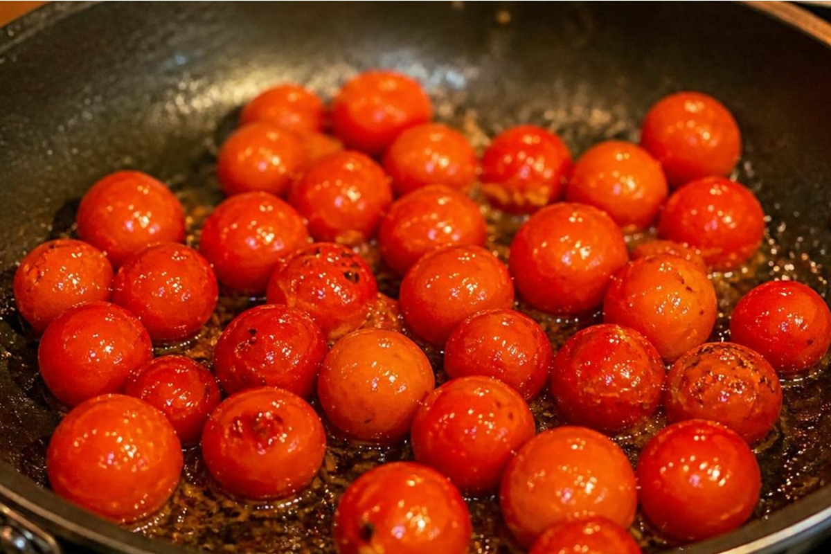 Cherry tomatoes cooked in a frying pan.