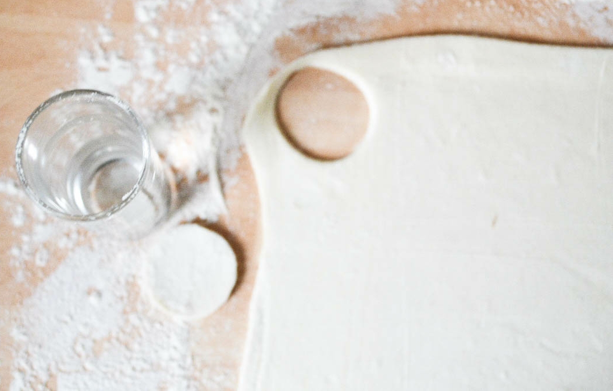 small circle cut out of rolled out puff pastry with a shot glass.
