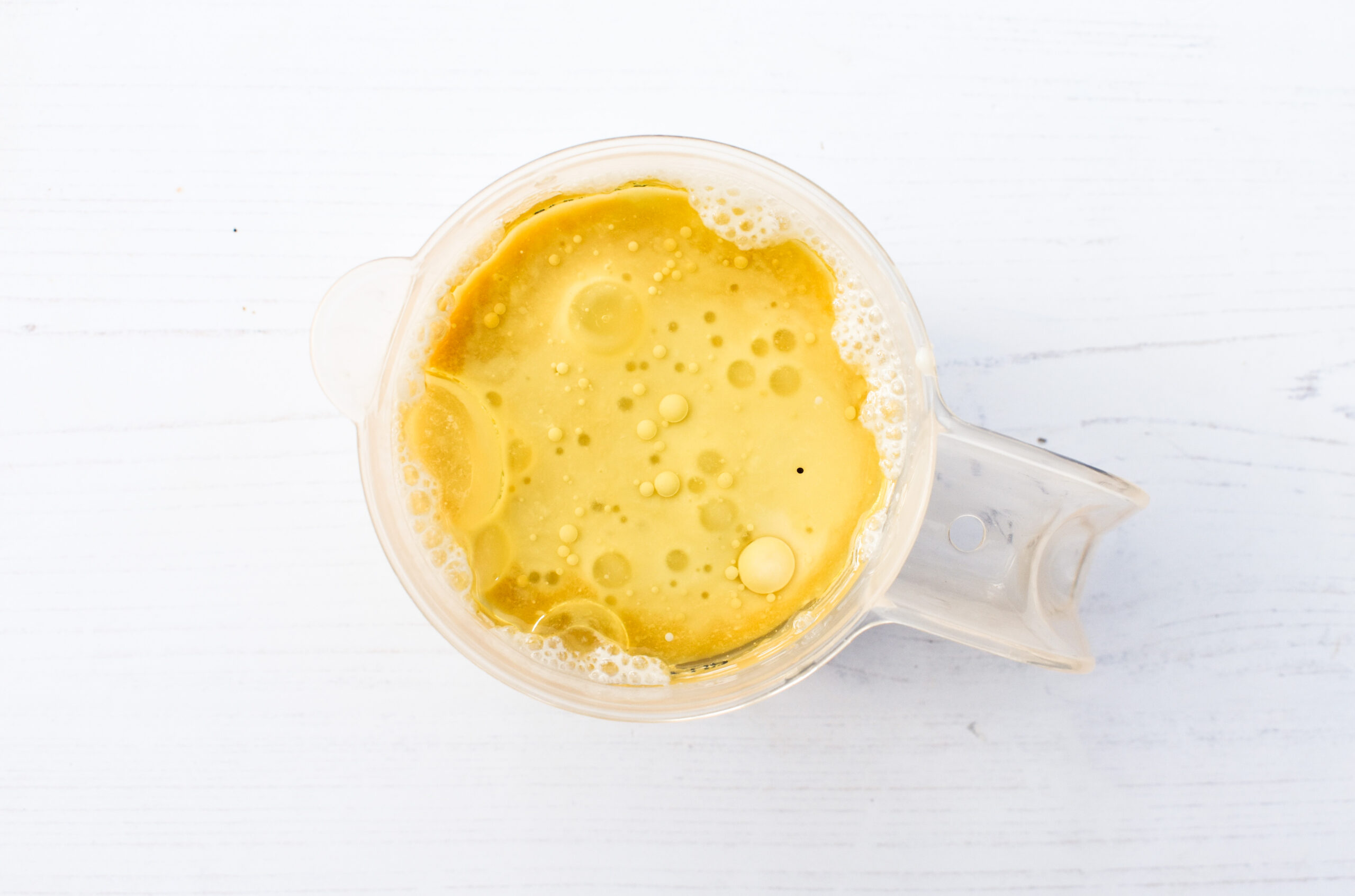 Oil added to vegan buttermilk in a jug.
