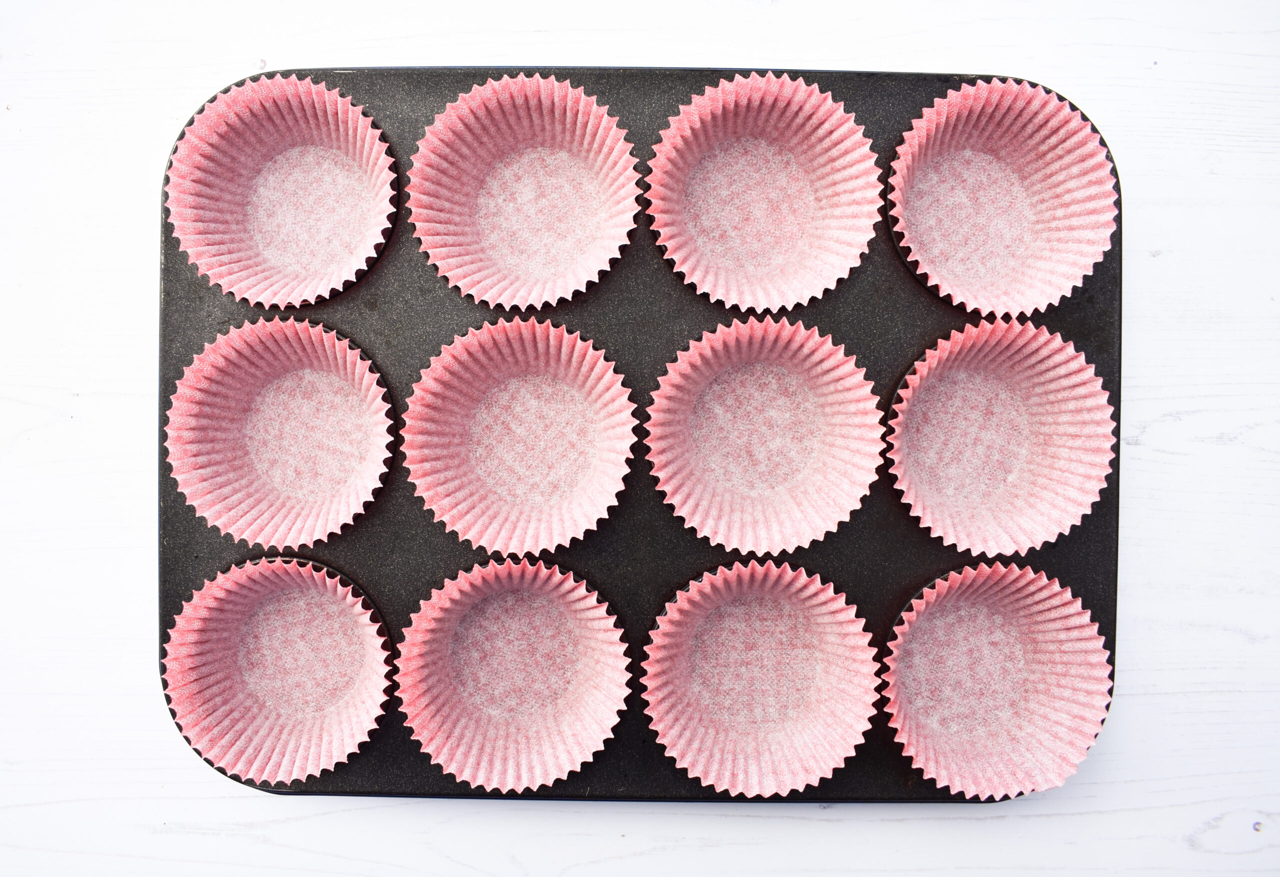 muffin tray filled with paper muffin cases.