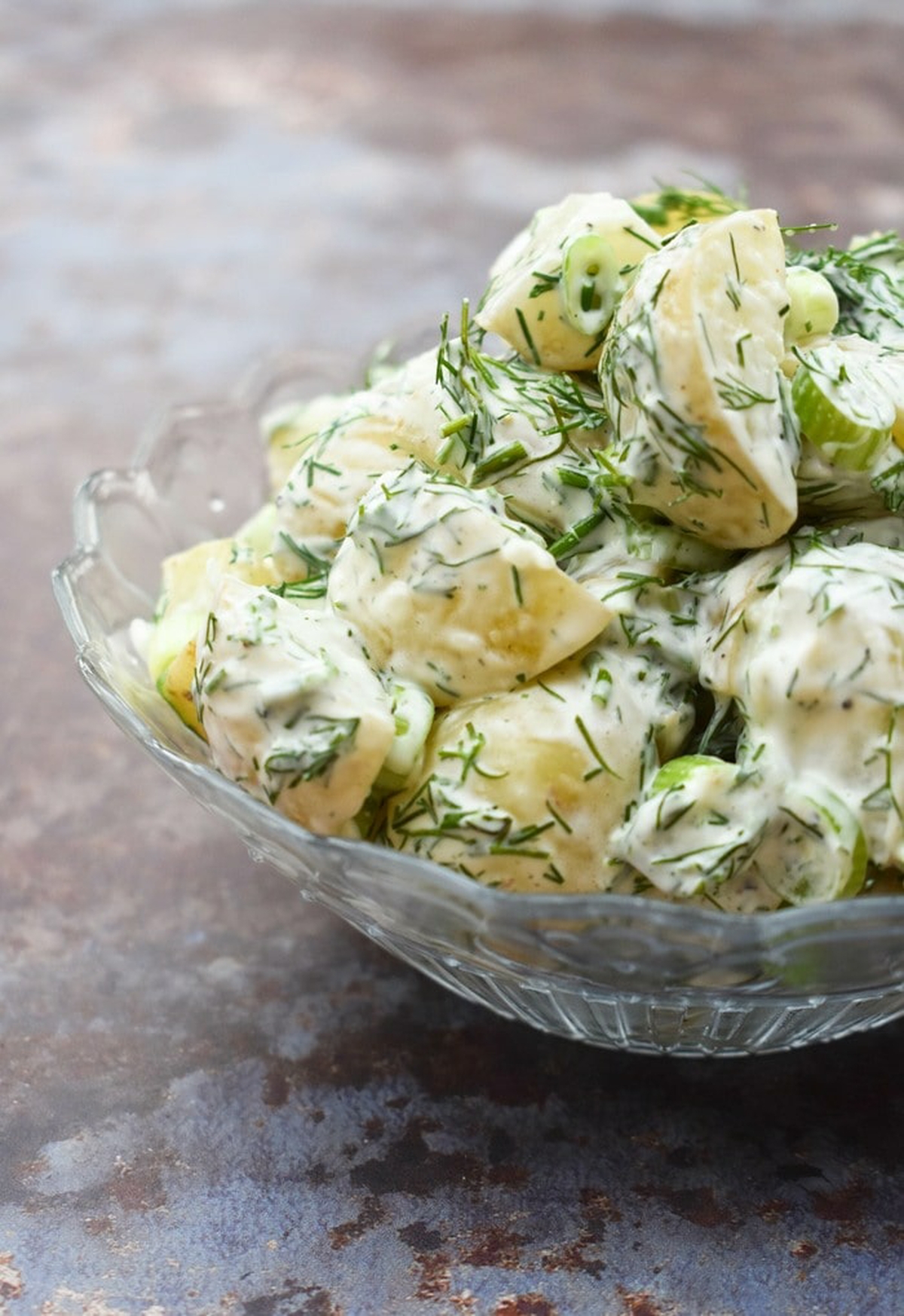 Finished potato salad served in a glass bowl.