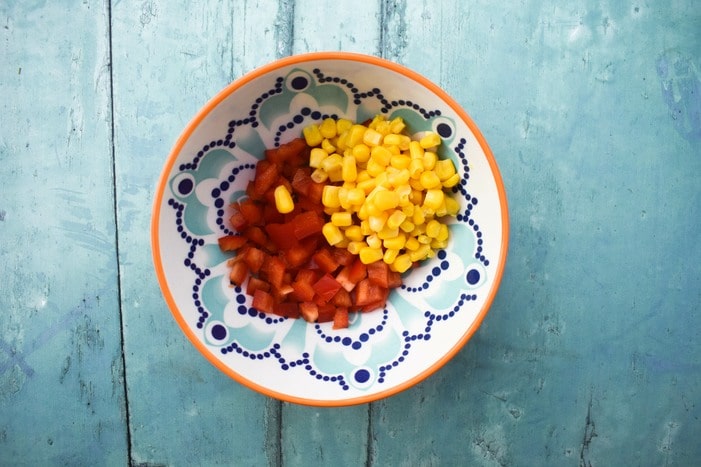 Making vegan macaroni step 2 - corn and red pepper in a bowl.