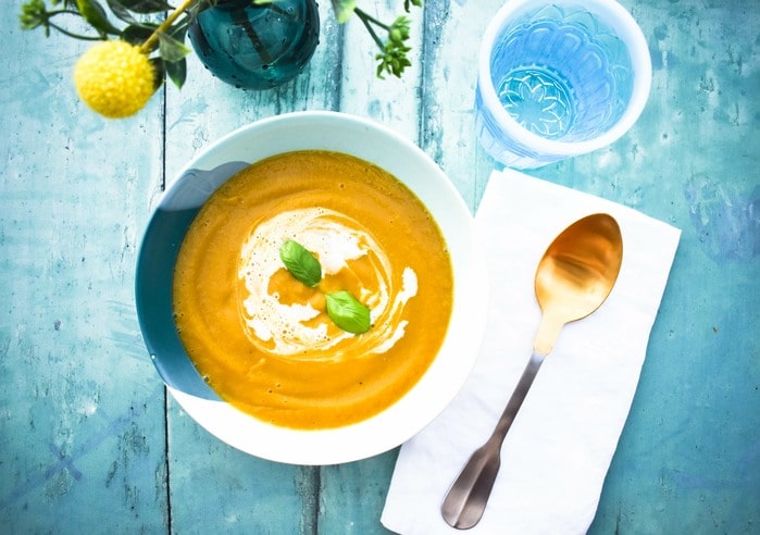 easy vegan roasted butternut squash soup served topped with a swirl of cream.