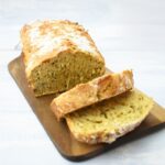 Sliced cheese and chive beer bread on a wooden board
