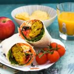 Onion Bhaji Lunch Wrap served with cherry .tomatoes.