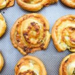Vegan pesto cheese swirls on a baking sheet
