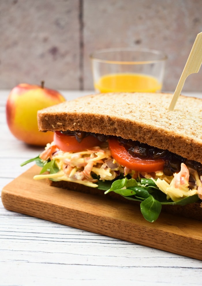 Vegan Cheese Savoury, a traditional British Sandwich filling, served on brown bread with salad, tomatoes and pickle.