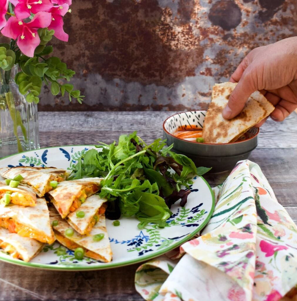 Quesadilla dipped in creamy sriracha dip