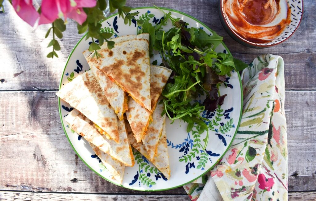 vegetable quesadillas on a patterned plate with salad leaves