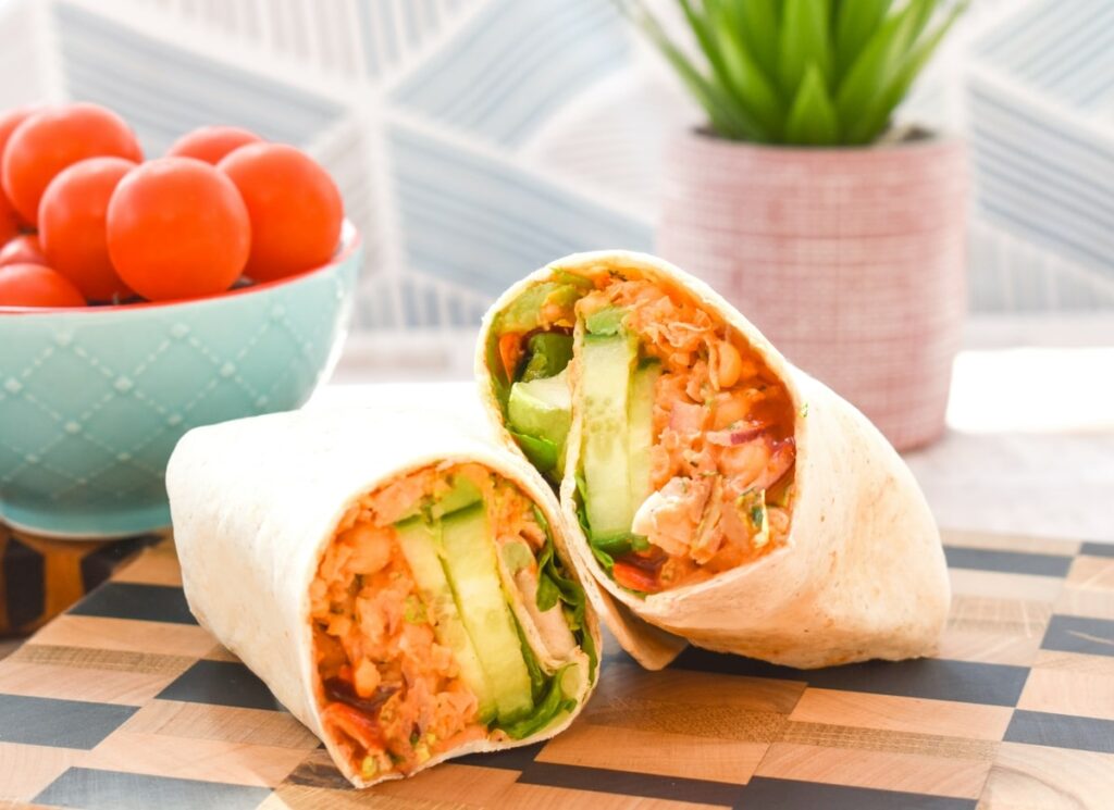 Sriracha & Avocado Chickpea Wraps on a wooden board