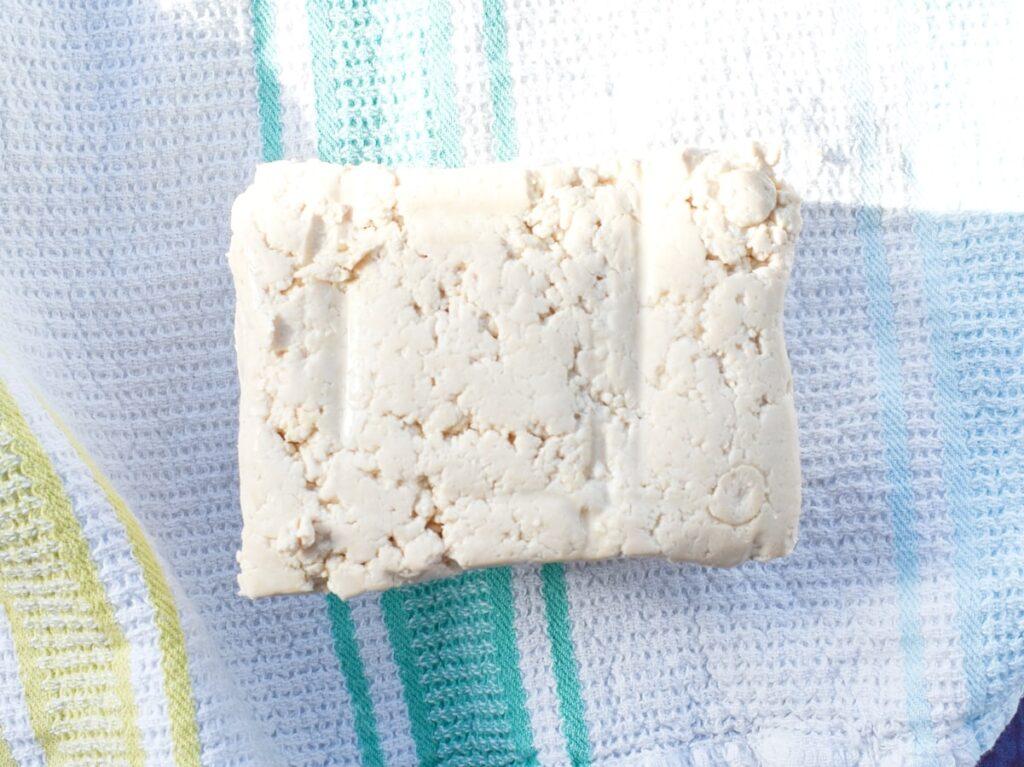 Extra Firm Tofu block on a clean tea towel.