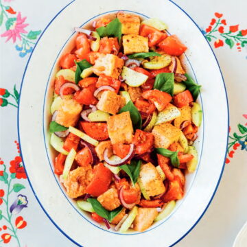 Vegan Panzanella Salad on a platter topped with fresh basil.