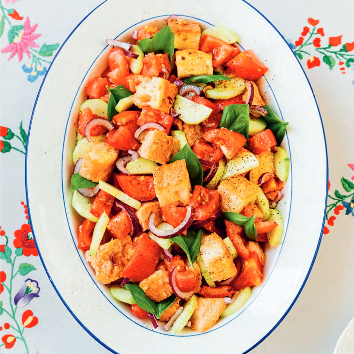 Vegan Panzanella Salad on a platter topped with fresh basil.