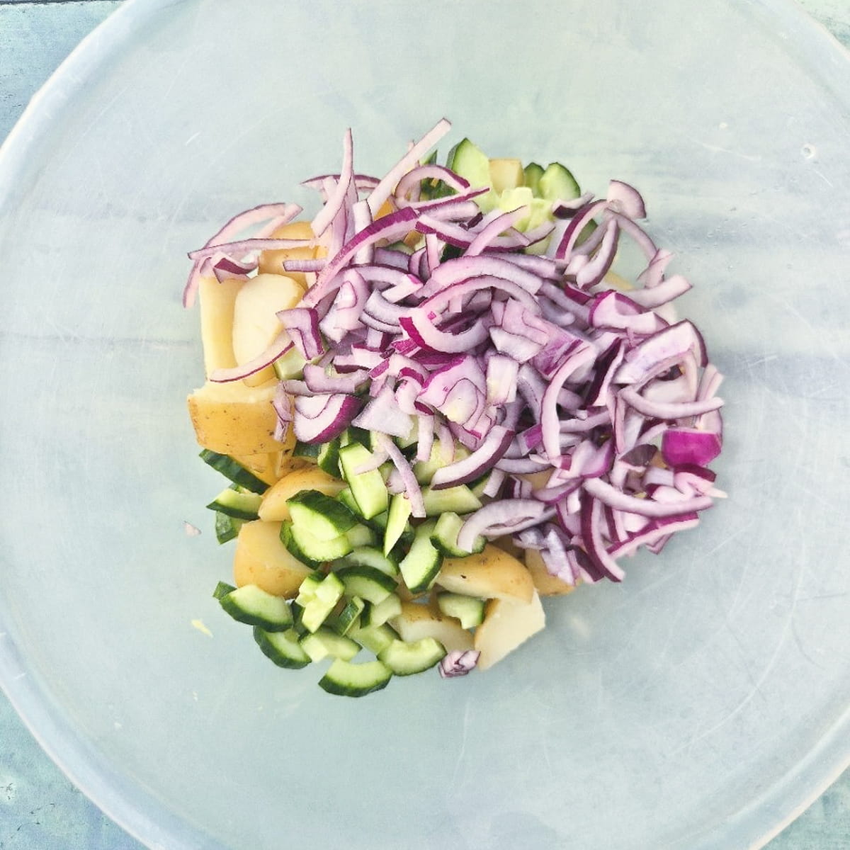 thousand island potato salad - step 4 - add the sliced onion and cucumber to the potatoes.